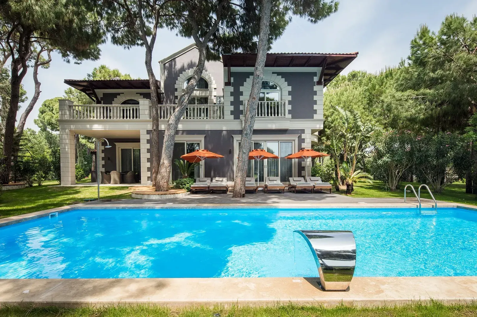 Villa bahçesinde tamamlanmış Fiplus havuz ve kenarında paslanmaz şelale